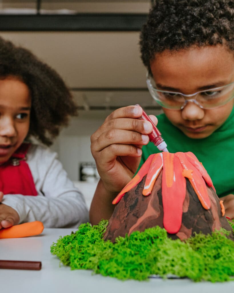 children making diy volcano model from kids play clay